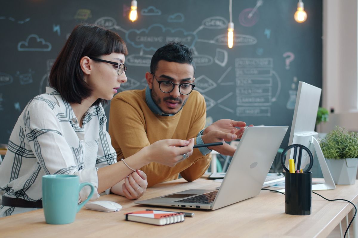 Two colleagues going through work on a laptop