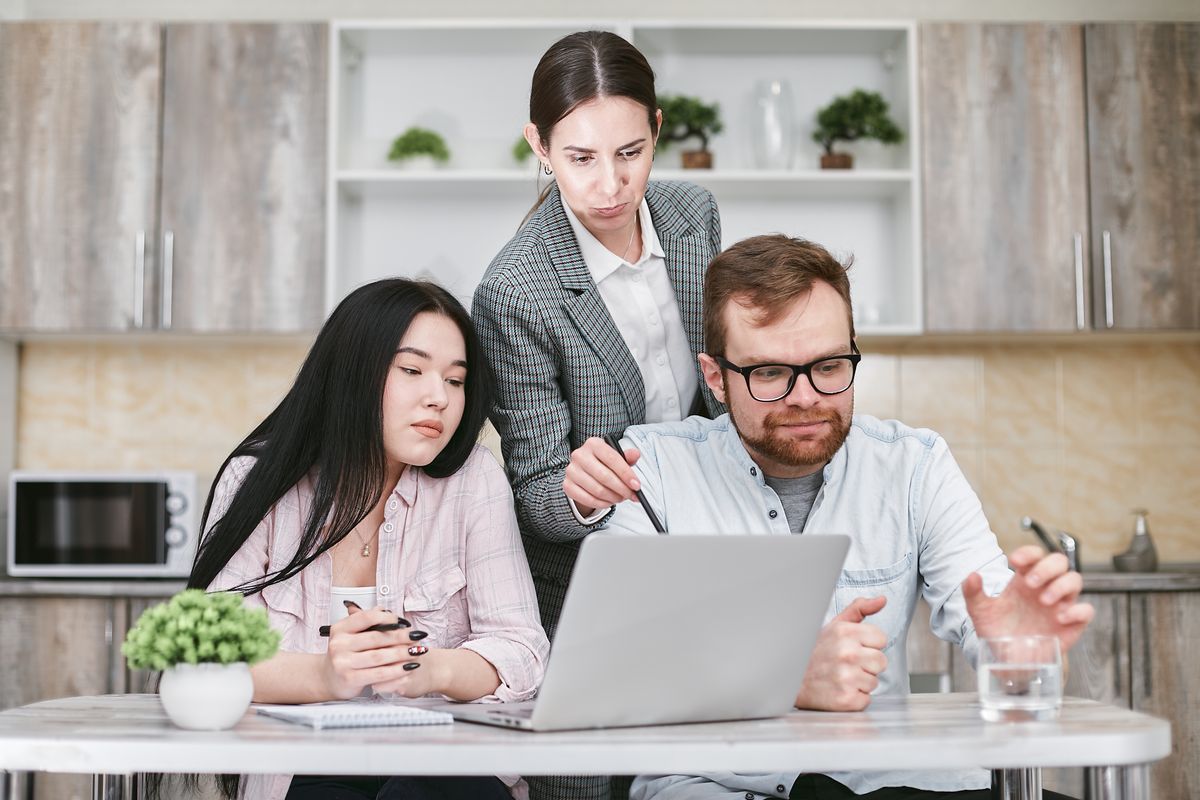 Coworkers comparing notes at a desk